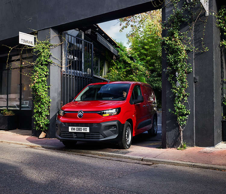 Новий фургон Citroën ë-Berlingo виїжджає з двору на вулицю у місті